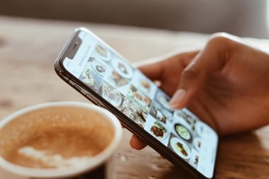 Find the right influencers for your marketing goals - person holding phone and browsing instagram